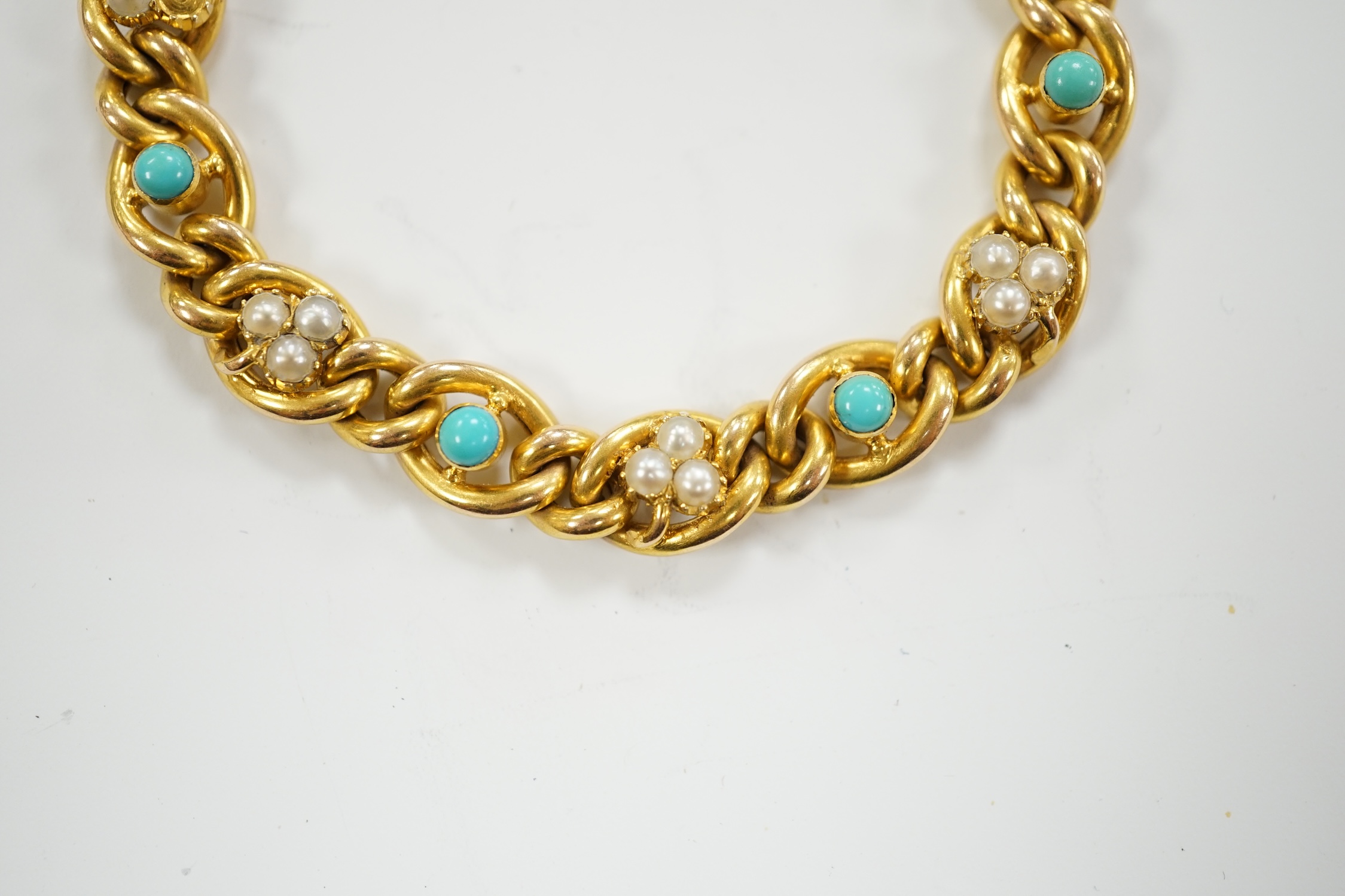 An Edwardian yellow metal (stamped 15), seed pearl cluster and turquoise bead set curb link bracelet, 18cm, gross weight 16.2 grams.